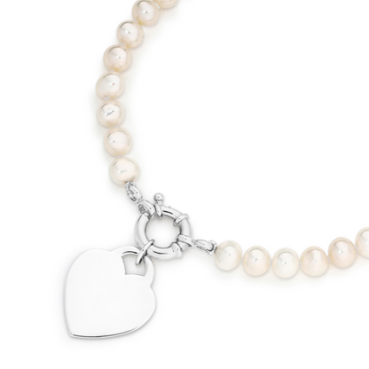 Pearl necklace with silver heart shaped charm hanging from a bolt ring
