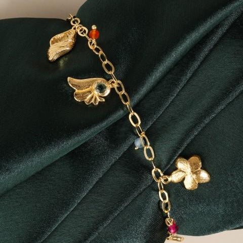 Close up of charm bracelet on dark green satin