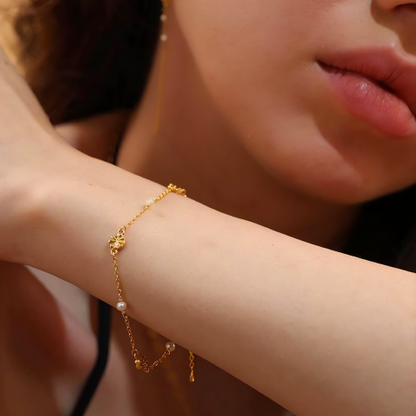 Model with dainty gold and pearl bracelet on wrist