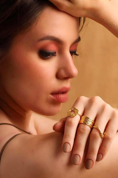 Young woman posing with multiple gold plated ring on hand over shoulder